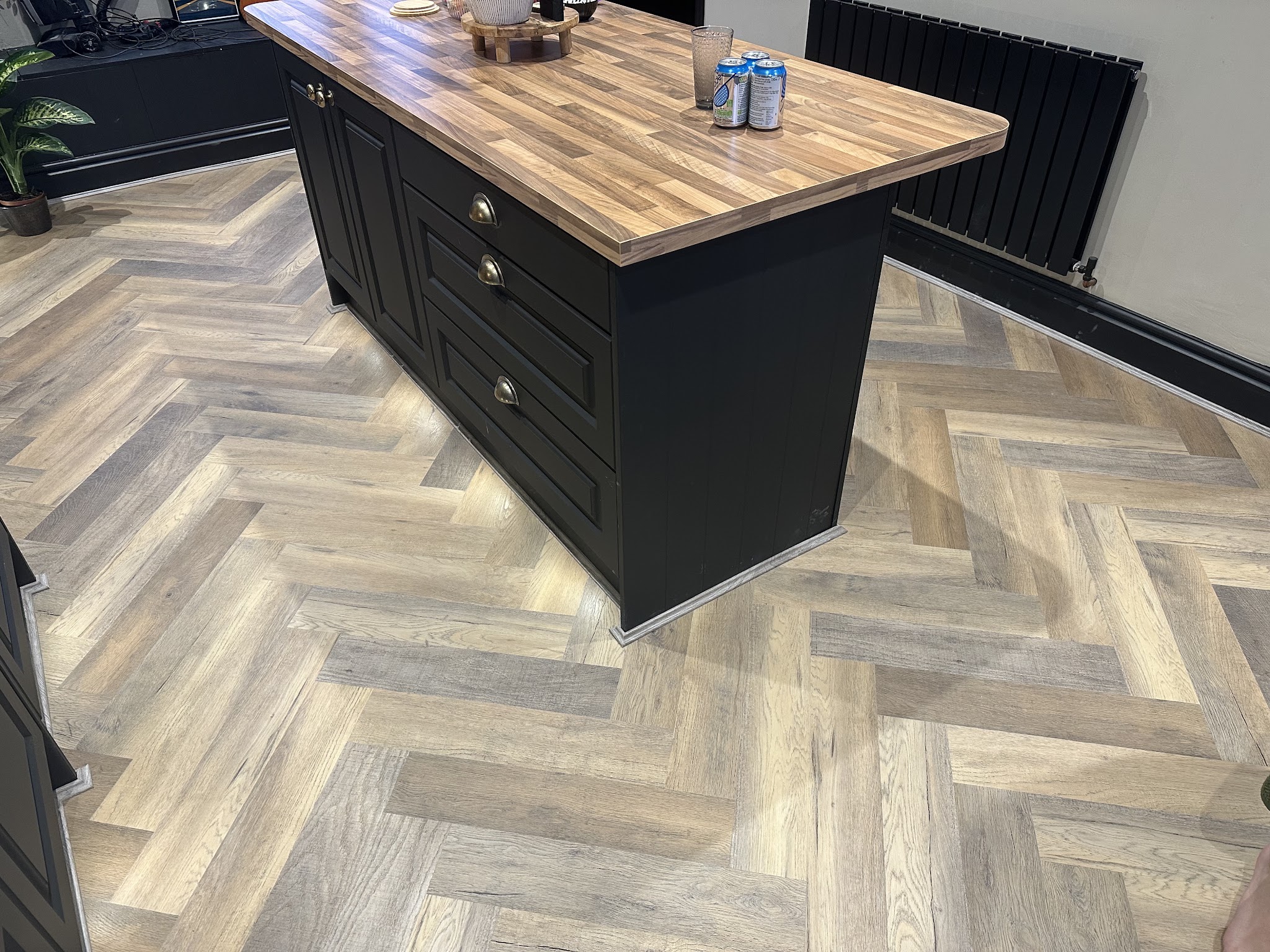 Herringbone-patterned flooring around a kitchen island